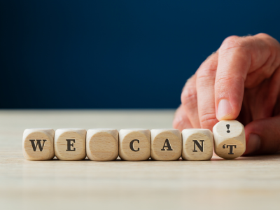 dice with letters that spells out "we can't" and the letter T is rolled to exclamation mark to spell out "we can"